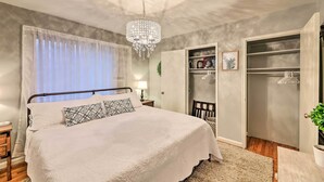 Ein Schlafzimmer mit Bett, einer Deckenleuchte, einem Kleiderschrank und einem Nachttisch.