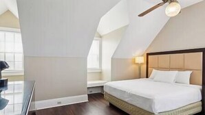 A bedroom with a bed, a ceiling fan, and a window. - Oak Cottage R304 (Lafitte)
