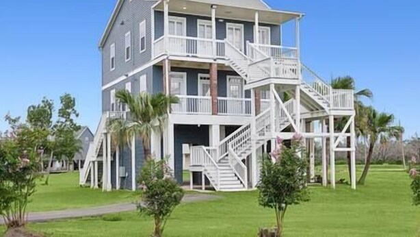 A multi-story building with a balcony and a staircase. - Cypress Cottage R4 (Lafitte)