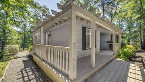 A wooden deck with a pergola, surrounded by trees. - Waterfront Urbanna Home w/ Private Dock (Urbanna)