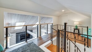 A spacious loft with a high ceiling, large windows, and a wooden floor. - Waterfront Urbanna Home w/ Private Dock (Urbanna)