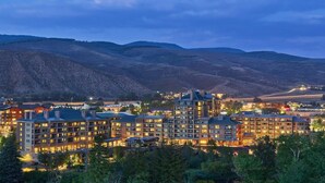 A multi-story hotel with a central courtyard, surrounded by hills.