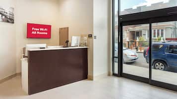 A reception desk with a sign indicating free Wi-Fi in all rooms.