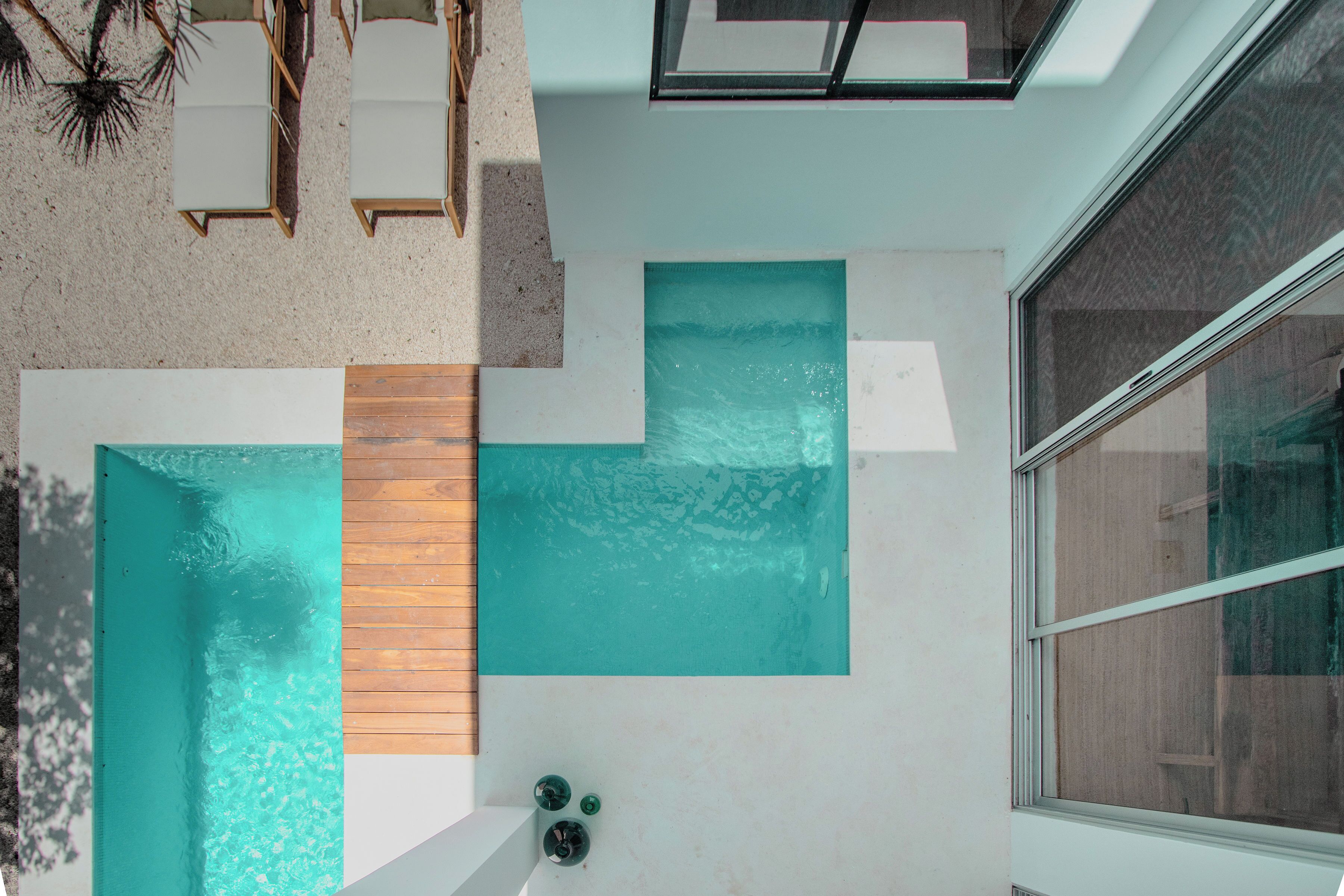 A modern bathroom with a large bathtub, a wooden panel, and a window.