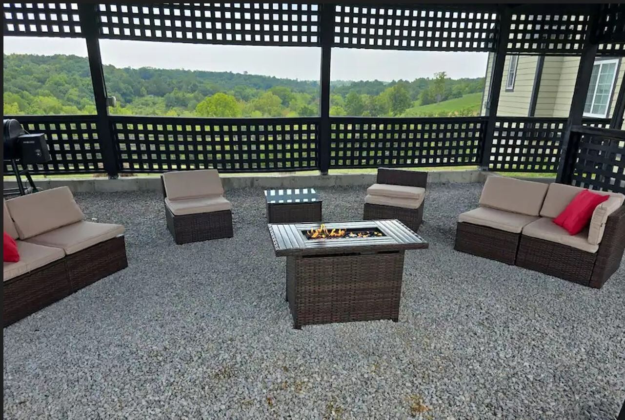 Een terras met rieten meubilair en een vuurkorf.