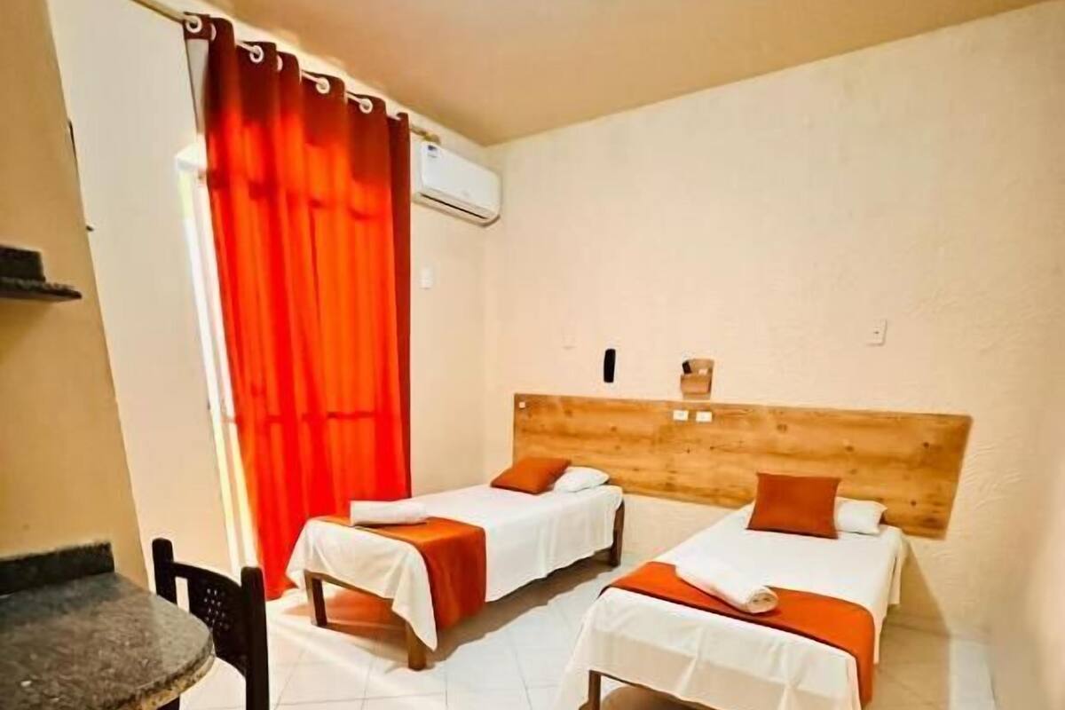 A room with two beds, a small table, and a chair.