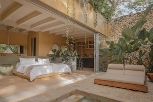 Un dormitorio con cama, sofá y una pequeña zona de piscina.