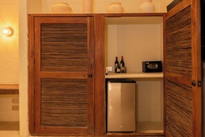 Una cocina compacta con armarios de madera, un refrigerador y un microondas.