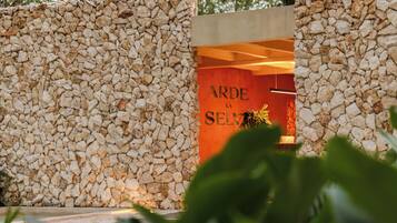 Um muro de pedra com uma placa que diz 'ARDE LA SELVA'.