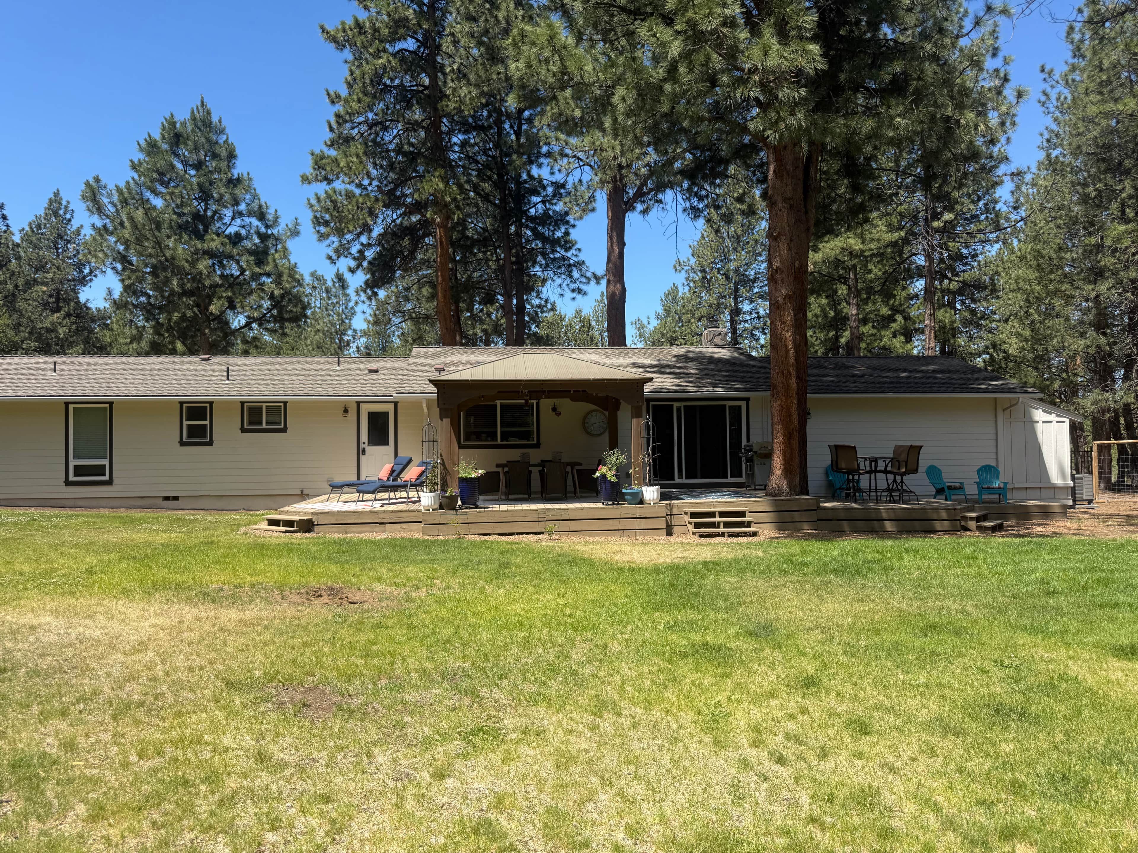 A single-story house with a covered patio area, a small deck, and a fenced yard.