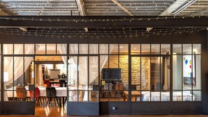 Un interno moderno con zona pranzo, cucina e parete in pietra.