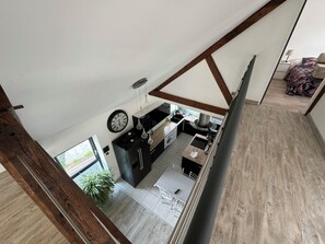A modern kitchen with a central island, a dining area with a table and chairs, and a view of the outdoors through a window. - Loft near downtown (Nevers)