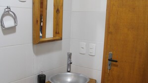 Une salle de bain avec un meuble-lavabo en bois, un évier et un miroir.