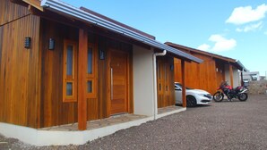 Un bâtiment aux murs extérieurs en bois, doté d’un porche couvert et d’une allée gravillonnée.