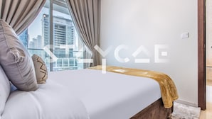 Ein modernes Schlafzimmer mit einem großen Bett, Blick auf die Stadt und einem Holzkopfende.