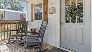 A porch with two rocking chairs and a wooden fence in the background. - Lucky Star Ranch - Shooting Star (Bandera)