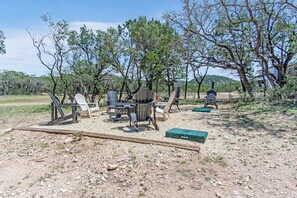 An outdoor seating area with chairs and tables, surrounded by trees and a barbecue grill. - Lucky Shooting Star #3 | Romantic Stay Near Parks (Bandera)