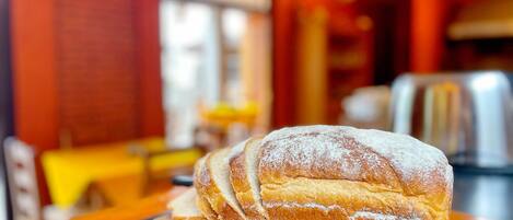 A loaf of bread on a wooden board in a restaurant setting.