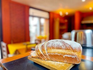 A loaf of bread on a wooden board in a restaurant setting. - Sandunga Suites Patzcuaro (Patzcuaro)