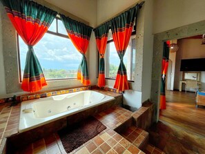 A bathroom with a bathtub, tiled floor, and curtains. - Sandunga Suites Patzcuaro (Patzcuaro)