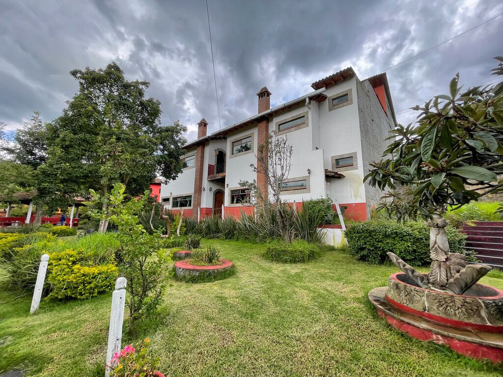 Un edificio de dos pisos con un jardín delantero.