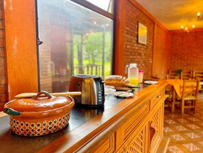A breakfast setup with a toaster, a jug of orange juice, and a ceramic pot on a wooden counter. - Sandunga Suites Patzcuaro (Patzcuaro)