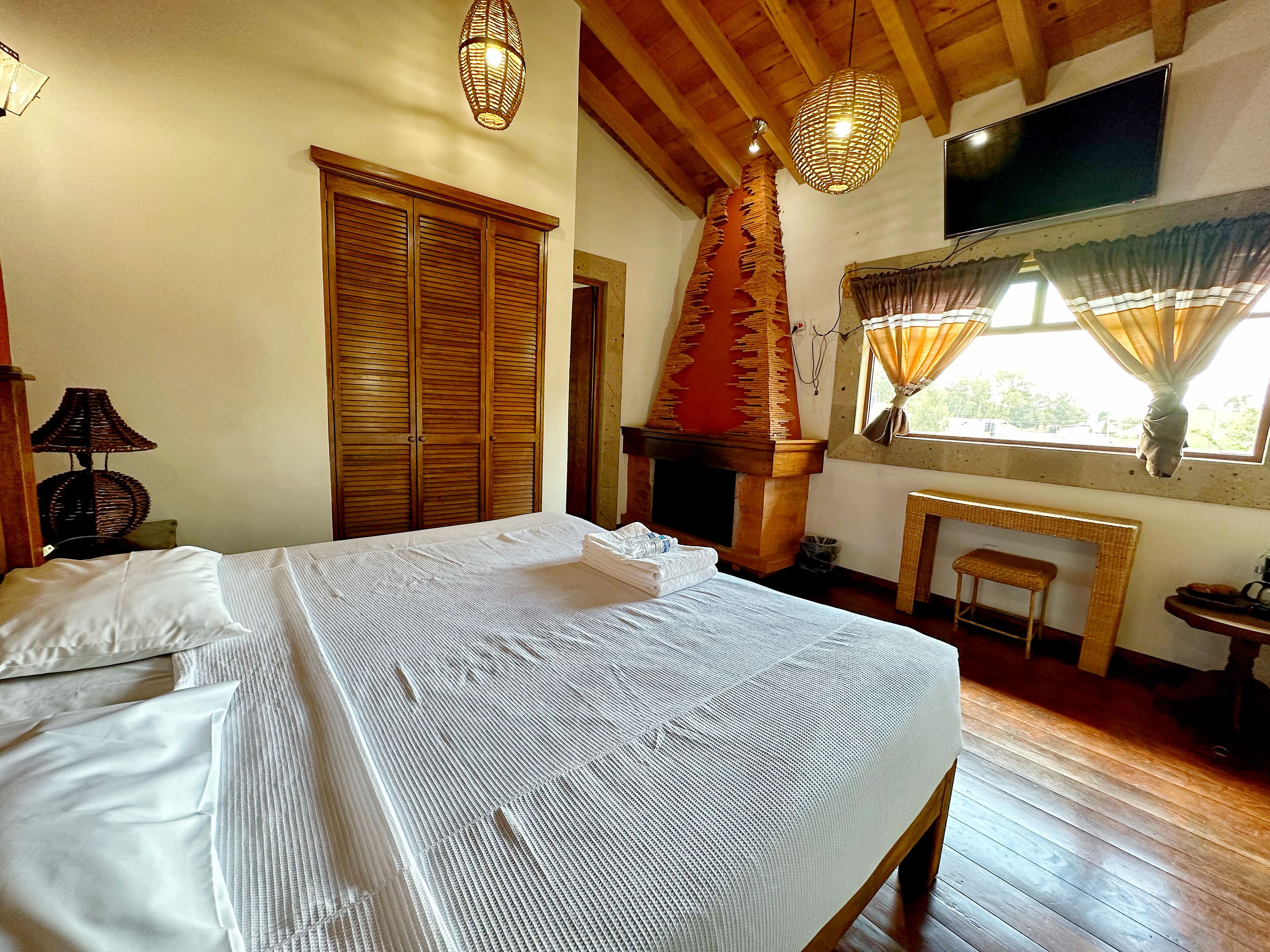 Un dormitorio con cama, armario de madera y chimenea.
