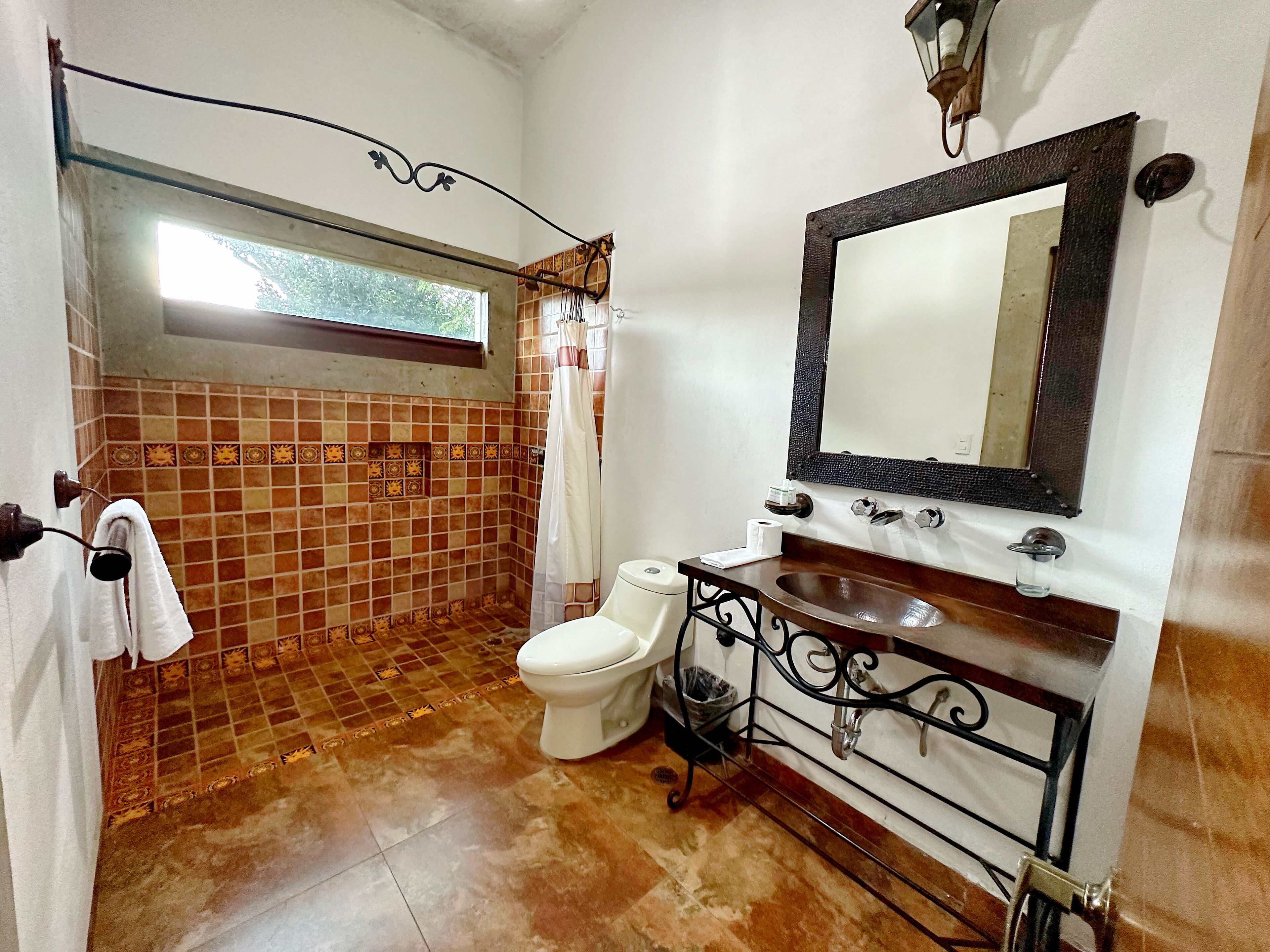 A bathroom with a shower, toilet, and sink.