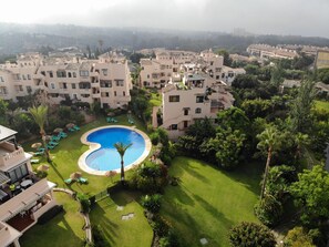 Relax by the central pool surrounded by lush greenery and lounge in style.