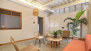 A room with wicker chairs, a wooden table, a pool table, and a large window with blinds. - Botánica Manila by HOUSY HOST (Medellín)