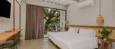 A bedroom with a bed, a desk, a chair, a TV, and an air conditioning unit.