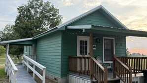 A small, single-story building with a porch and a wooden staircase leading to the entrance.