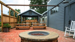 A patio with a wooden fire pit, wooden benches, and a covered seating area. - Peaceful Orchard Getaway! High-Speed Internet! (Lake Village)
