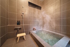 Comfort villa | Badkamer | Een aparte badkuip en douche, een bronwaterbad, gratis toiletartikelen