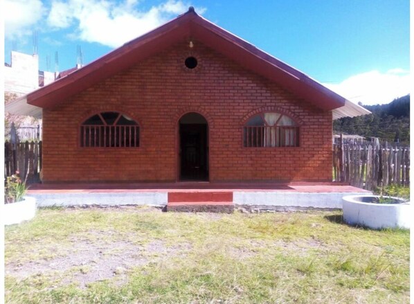 Simple, single-story building with a central entrance and barred windows.
