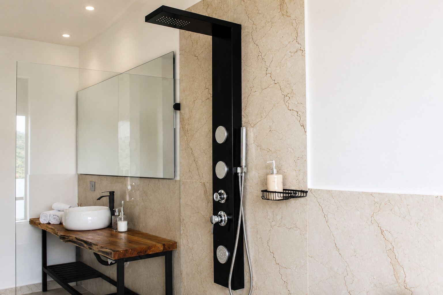 Un bagno moderno con parete in marmo, uno specchio grande, un mobile lavabo in legno, un box doccia nero e un piccolo ripiano con articoli da toilette.