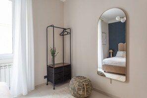 A bedroom with a bed, a hanging chair, a mirror, and a radiator. - Daplace - Cosima Apartment (Roma)