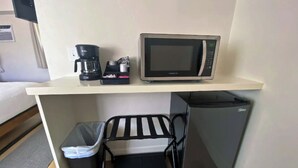Een kleine keuken met een magnetron, koffiezetapparaat en een kleine koelkast.