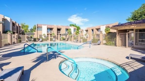 Un espace piscine comprenant des chaises longues et une piscine à bord incurvé.