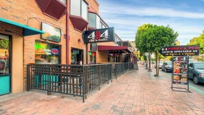 Un bâtiment en briques sur lequel on peut lire l’enseigne « 4th of July Pizza & Pub », et un panneau affichant le menu du jour et les offres spéciales pour le déjeuner.