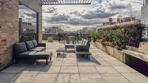 A rooftop terrace with a pergola, outdoor seating, and a view of the cityscape. - Nuevetres by Wynwood House (Bogotá)