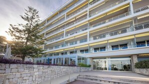 A multi-story hotel with balconies, a stone facade, and a glass entrance. - 06B - Beautiful apartment with terrace sea view (Roquebrune-Cap-Martin)