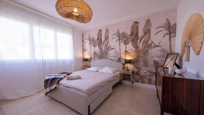 A bedroom with a bed, bedside tables, a dresser, and a wall mural. - 06B - Beautiful apartment with terrace sea view (Roquebrune-Cap-Martin)