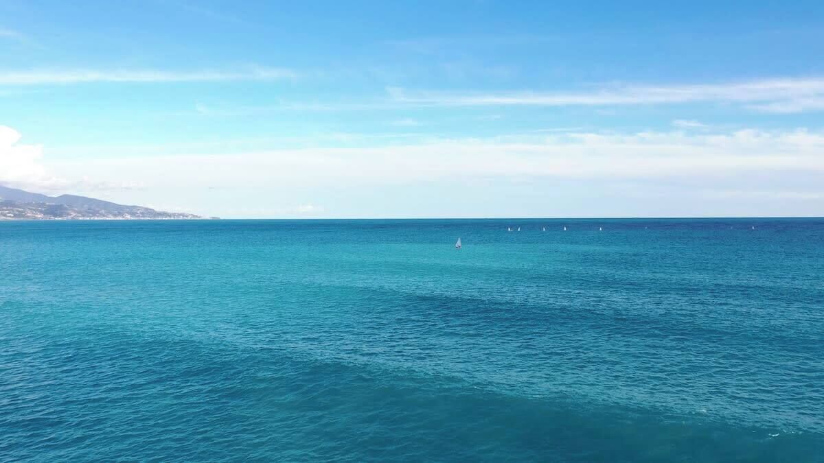 A coastal view with calm sea and distant land.