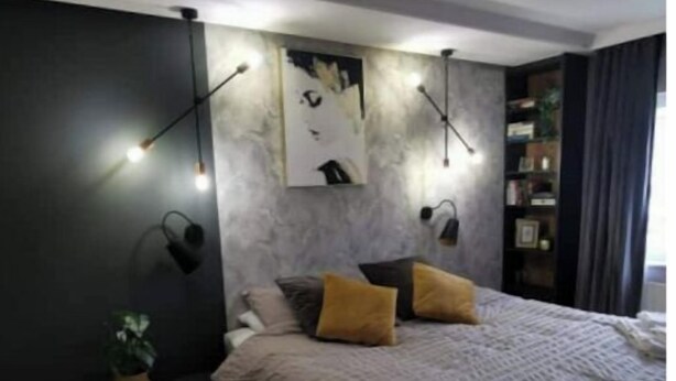 A modern bedroom with a bed, bedside tables, a nightstand, a wall-mounted shelf, and a potted plant. - Modern 4 bedroom house Dublin 20
 (Dublin)