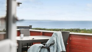 A balcony with a table and chairs, overlooking a body of water. - 2 bedroom cozy home in Esbjerg V (Esbjerg V)