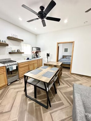 A compact kitchen with a gas stove, microwave, and wooden cabinets.