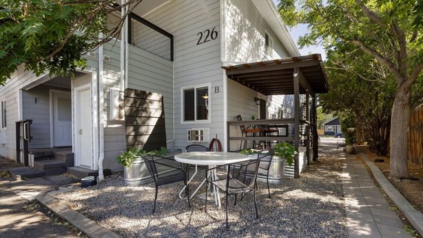 A house with a covered patio area, a gravel driveway, and a number '226' on the building.
