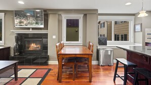 Una cocina moderna con chimenea, mesa de comedor y zona de bar.