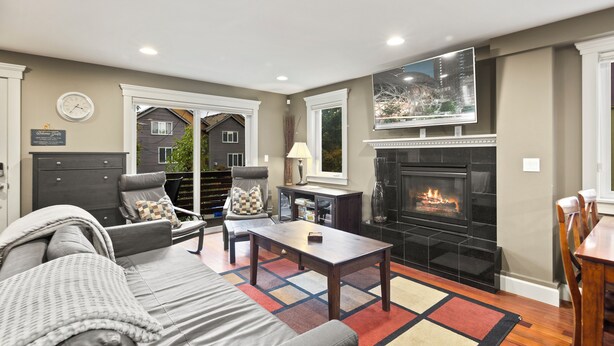 Una sala de estar con chimenea, sofá, sillón y mesa de centro.